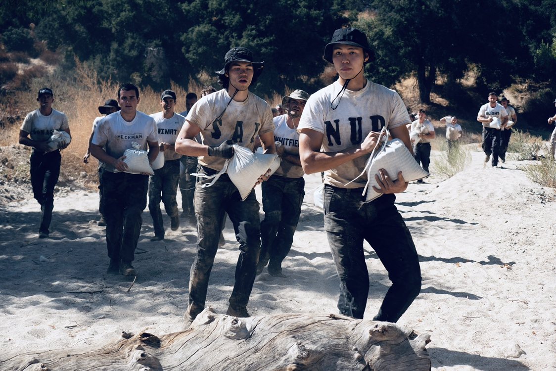 Nurtai carrying a sandbag with a column of trainees at SEAL Fit